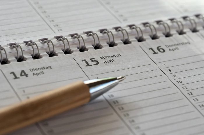 Agenda con penna, aperta su una pagina di calendario